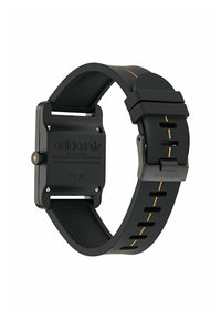 Montre de sport noire avec un boîtier en résine carré, une bande jaune en accent, et un bracelet en caoutchouc texturé comportant des perforations pour la ventilation.