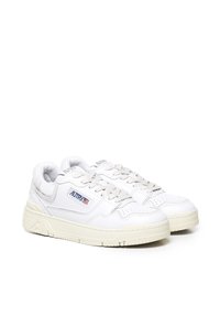 Zapatillas blancas de cuero con un acabado texturizado, que cuentan con una suela crema, cordones y una etiqueta de marca en el lateral. Diseño de punta redondeada.