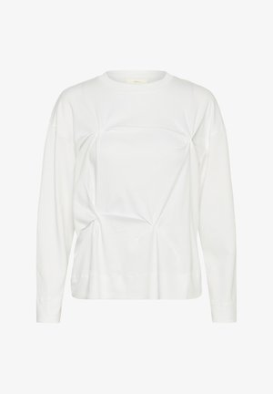 Balti ilgomis rankovėmis suapvalinta kaklo linija marškinėliai su parinktais audinio detalėmis, kurios sukuria nereguliarias žvaigždės formos priekinėje ir šoninėse dalyse.