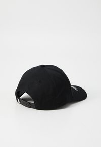 Black cotton cap with a curved brim, adjustable plastic strap, embroidered logo on the side, and a button on top.