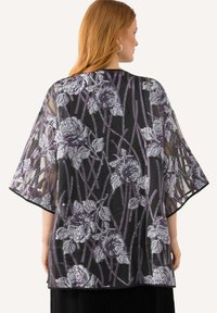 Průhledný černý kimono se květinovým vzorem v stříbrné a fialové barvě, s širokými rukávy a volným střihem, olemované černým lemem.