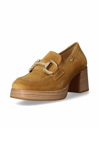 Mocassins à talons hauts en daim marron avec un détail de boucle en ton or, bout carré et talon en bois stratifié, présentant des coutures visibles.