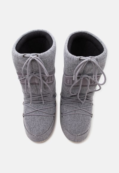 Paire de bottes d’hiver grises avec tissu épais, devant à lacets, et doublure intérieure douce, vues de dessus sur fond blanc.