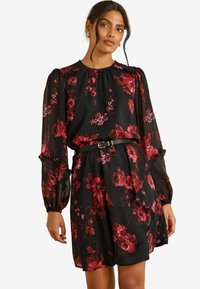 Rochie neagră cu flori, având trandafiri roșii, mâneci lungi din material transparent, gât strâns și talie ajustată evidențiată de o curea neagră. Material moale și ușor.