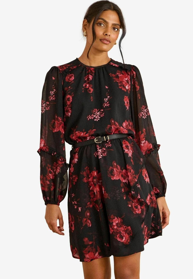 Rochie neagră cu flori, având trandafiri roșii, mâneci lungi din material transparent, gât strâns și talie ajustată evidențiată de o curea neagră. Material moale și ușor.