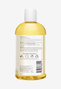 Kirkas muovipullo kylpyvaahdosta, keltainen neste, valkoinen korkki. Etiketissä takana teksti, ainesosalista ja kierrätystietoa.