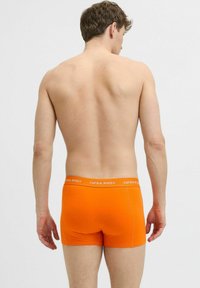 Oranje katoenen boxershorts met een strakke pasvorm, voorzien van een contrasterende witte logo-taillenband en minimale stikdetails.