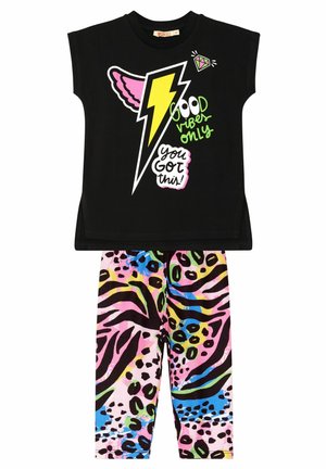 Sort kortærmet skjorte med farverige lyn og tekstgrafik, parret med lyserøde leopardmønstret leggings med grønne og blå accenter.