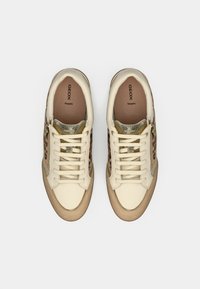 Beige leather sneakers with leopard print sides, gold accents, and white laces. Features a textured tongue and a rubber sole.