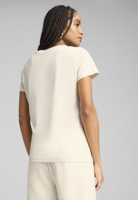 Beige kortebloem T-shirt van zachte stof. Heeft een ronde halslijn en een slim fit, met minimale stikseldetails.