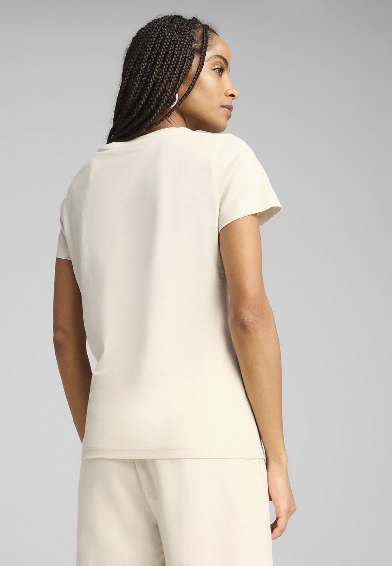 Beige kortebloem T-shirt van zachte stof. Heeft een ronde halslijn en een slim fit, met minimale stikseldetails.
