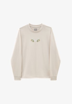 Langærmet lysebeige t-shirt lavet af bomuld, med en blomsterbroderi-design i grøn og hvid centreret på brystet.