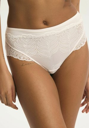 Biele čipkované nohavičky s vysokým pásom a vzorom listov, ktoré nosí osoba so stredne hnedou pokožkou, viditeľným pupkom a čiastočným tetovaním na hornej časti stehna.