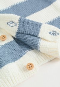 Jersey de punto con franjas alternas en azul claro y crema, con una textura de puntos elevados y botones de madera natural.