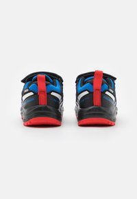 Zapatillas de trail running en azul y negro con acentos rojos, parte superior de tela texturizada, detalles reflectantes y suela de goma con un patrón de agarre pronunciado.