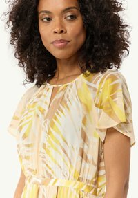 Luftiges, transparentes Kleid mit einem Muster aus gelben und beigen Blättern, kurzen, schwingenden Ärmeln und einem Ausschnitt mit Schlitzdetail sowie Falten.