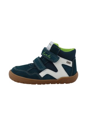 Zapatilla de niño alta en azul marino y blanco con interior verde, tiras de velcro y suela de goma marrón.