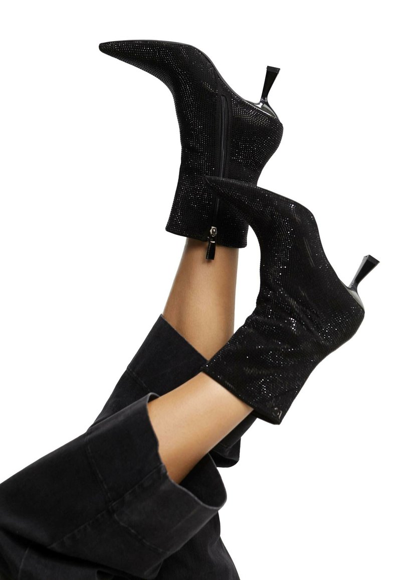 Čierne členkové topánky s špicatou špičkou, vyrobené z textúrovaného materiálu, so zipsom a úzkym vysokým ihlovým podpätkom.