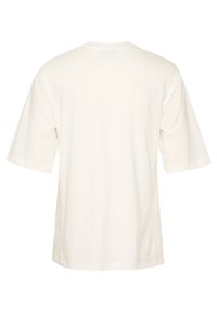 Camiseta de algodón crema de manga corta y cuello redondo. Presenta un corte relajado con una textura suave y sin logotipos ni adornos visibles.
