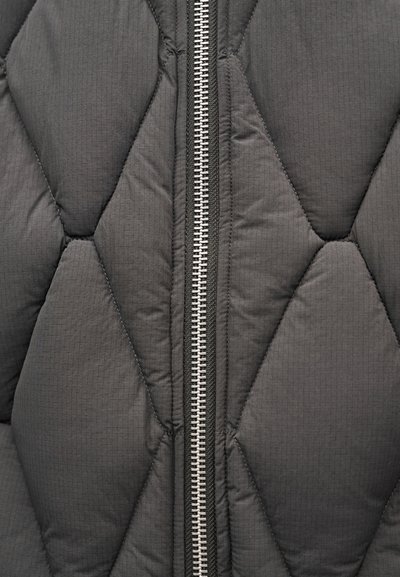 Fekete, steppelt pufidzseki ezüst cipzárral, mintás gyémánt alakzatokkal és kontrasztos fekete varrással.