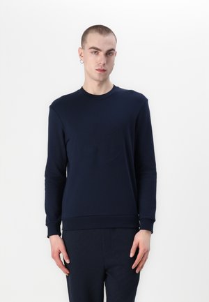 Navy sweatshirt with a crew neckline and ribbed cuffs. Features a subtle embossed logo on the chest, made from smooth, stretchy fabric.