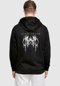 Czarna bluza z kapturem z białym wzorem "SLEEP TOKEN" na plecach, złożonym z wyszukanej linii i wzorów. Wykonana z miękkiego materiału.