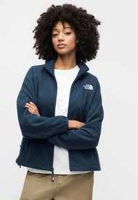 Μπλε ναυτικό μπουφάν από φλις με φερμουάρ στο γιακά, διαθέτει διακριτικό λογότυπο στο αριστερό μέρος του στήθους και ρυθμιζόμενο τελείωμα. Μαλακή υφή.