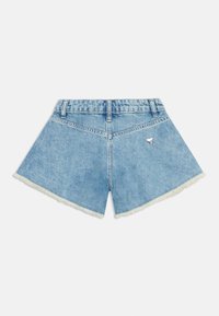 Shorts de mezclilla azul claro con forma acampanada, dobladillo deshilachado y un detalle de logotipo triangular plateado en el bolsillo trasero.