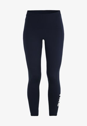 Tmavě modré legíny vyrobené z elastického materiálu, s vysokým pasem a bílým logem na levé noze. Hladký, přiléhavý design.