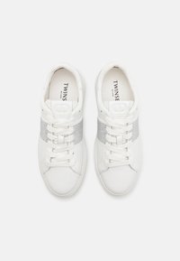 Sneakers bianchi con finitura in pelle liscia, caratterizzati da un accento in rete argentata sulla parte superiore e allacciatura standard. Marchio visibile all'interno.
