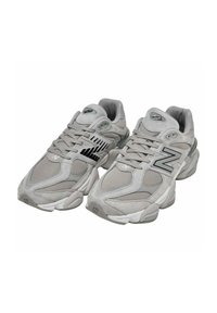 Scarpe sportive grigie realizzate in mesh e suede, dalla forma arrotondata, superficie testurizzata, logo prominente sul lato e dettagli neri.