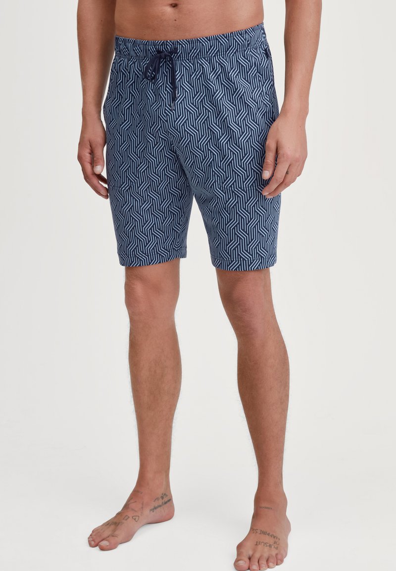Marineblauwe zwembroek met een geometrisch patroon, verstelbare tailleband, boven de knie lengte, en een gladde katoenmix stof.