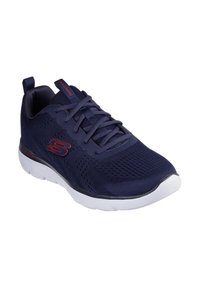 Bottines de sport bleu marine avec un dessus en mesh, dotées de lacets ton sur ton, d'une semelle rembourrée et d'une semelle intermédiaire blanche agrémentée d'accents rouges.