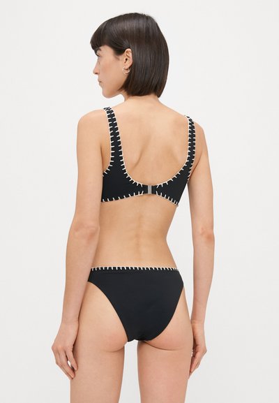 Sorte bikini sett med kontraststing, scoop rygg, og høyutsnittet truse. Materialet ser glatt ut med en elastisk tekstur.