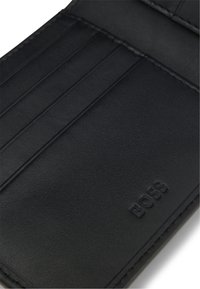 Tarjetero de cuero negro con cuatro compartimentos verticales para tarjetas y el logo "BOSS" en relieve en la esquina inferior derecha.