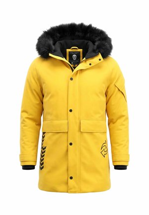 Felgele winterjas met zwarte bontbies aan de capuchon, knopen aan de voorkant, zijzakken en zwarte grafische details op de mouwen en onderaan de voorkant.