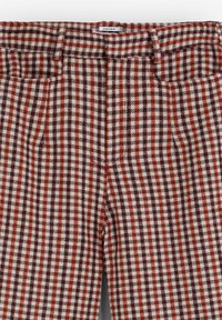 Pantaloni cu carouri, având un tipar roșu și alb, cu o croială ajustată, talie structurată și buzunare laterale. Realizați dintr-un material țesut.