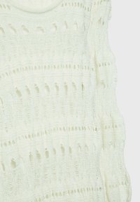 Haut tricoté en jaune pâle avec un motif ajouré, encolure dégagée et manches courtes. Présente un design texturé avec des lignes verticales et horizontales.