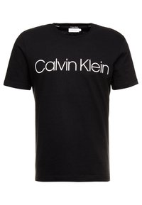 Musta puuvillapaita, jossa on pyöreä kaula-aukko, lyhyet hihat ja voimakas valkoinen "Calvin Klein" -logo rintamalla.