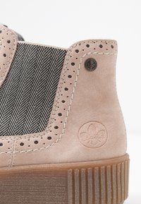 Zapatilla de ante rosa con tejido de espiga negro, acentos perforados, detalles de costura, logo en relieve y suela de goma estriada.