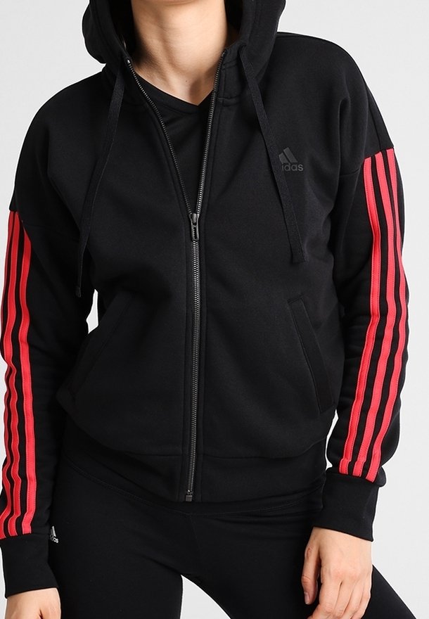 Sweat à capuche noir zippé avec une capuche, présentant des rayures rouges le long des manches. Confectionné dans un tissu doux avec des poches kangourou.