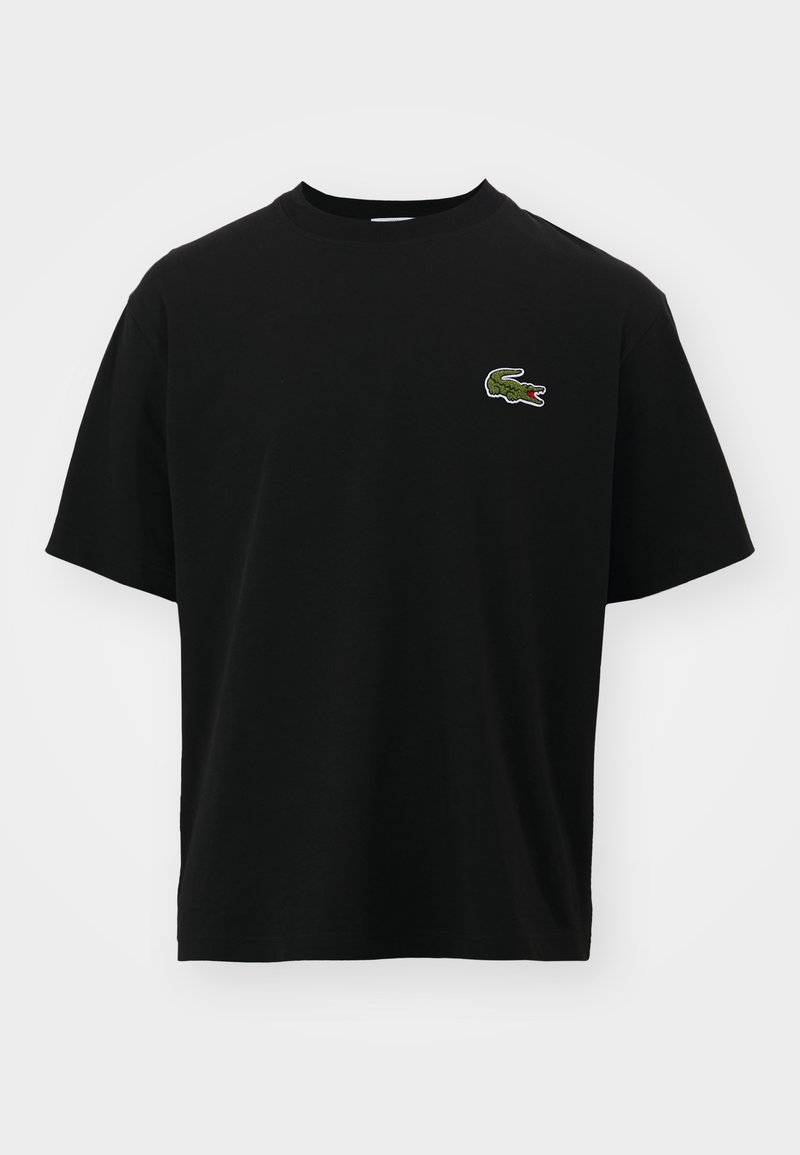 T-shirt noir à manches courtes avec col rond et petit logo crocodile vert sur la poitrine gauche.