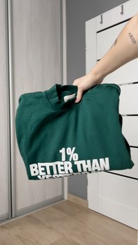 Felpa verde in tessuto morbido, con colletto a costine e audace scritta bianca sulla parte anteriore che recita "1% MEGLIO DI IERI".