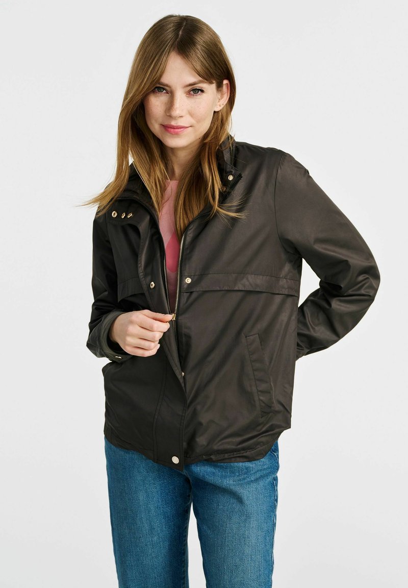 Czarna wodoodporna kurtka z zamkiem błyskawicznym i zapięciem na napy, z kołnierzem stojącym, bocznymi kieszeniami i gładką fakturą. Casualowy design z długimi rękawami.