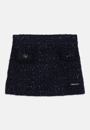 Navy fuzzy gebreide rok met een gestructureerd patroon, twee kleine voorzakken en metalen logo-accenten. Kenmerkt zich door een rechte zoom en een brede tailleband.