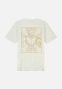 Witte katoenen t-shirt met een grote gouden grafische afbeelding op de achterkant, die abstracte vormen, golven en een centraal embleem afbeeldt.