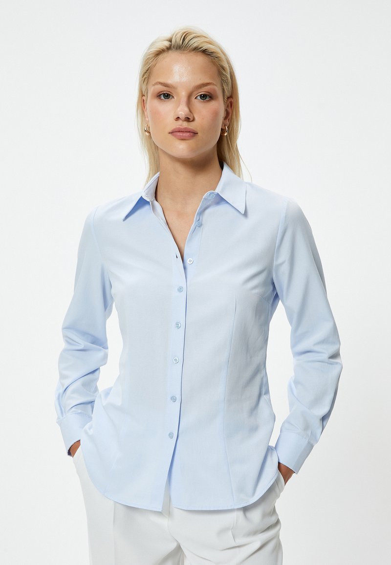 Lichtblauwe, lange mouwen button-up overhemd met een klassieke kraag, getailleerd ontwerp en subtiele textuur. Voorzien van knoopsluiting en gebogen zoom.