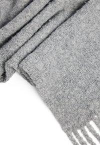 Grau Wolle Schal mit einer strukturierten Oberfläche, mit fransigem Rand und glatter Oberfläche, gefaltet zur Präsentation. Weiches und warmes Material.