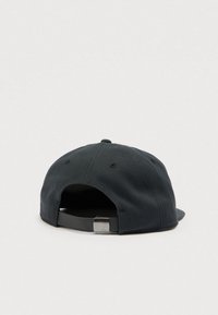 Μαύρο καπέλο με καμπυλωτό γείσο, υφασμάτινη υφή και ρυθμιζόμενο λουράκι με μεταλλική λεπτομέρεια στο πίσω μέρος.