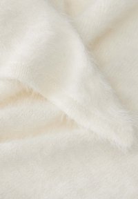 Tessuto lavorato a maglia bianco e morbido, con una consistenza soffice e motivi di punto variabili. Gli strati mostrano un design delicato e leggero.